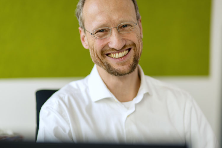 Businessportrait lachender Maitarbeiter